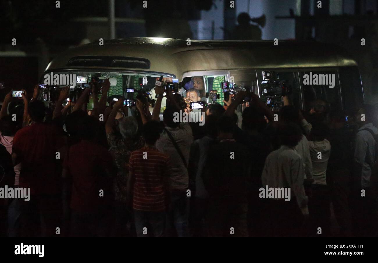 Il personale dei media circondò un minibus dove dodici organizzatori del movimento studentesco anti-discriminazione uscirono da Bangabhaban dopo aver incontrato i pres Foto Stock