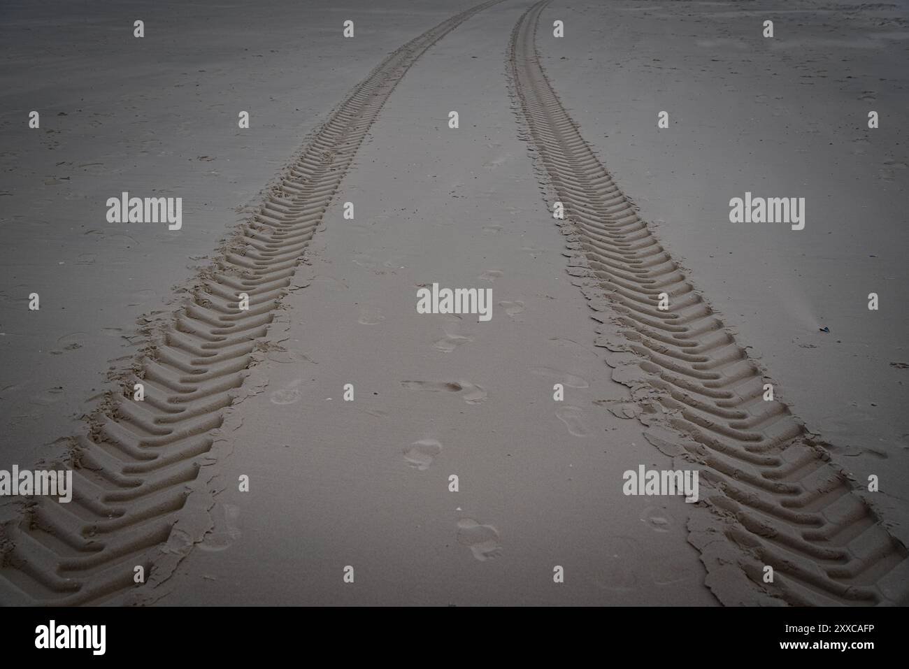 Tracce di viaggio: Segni di pneumatici nella sabbia sulla spiaggia Foto Stock