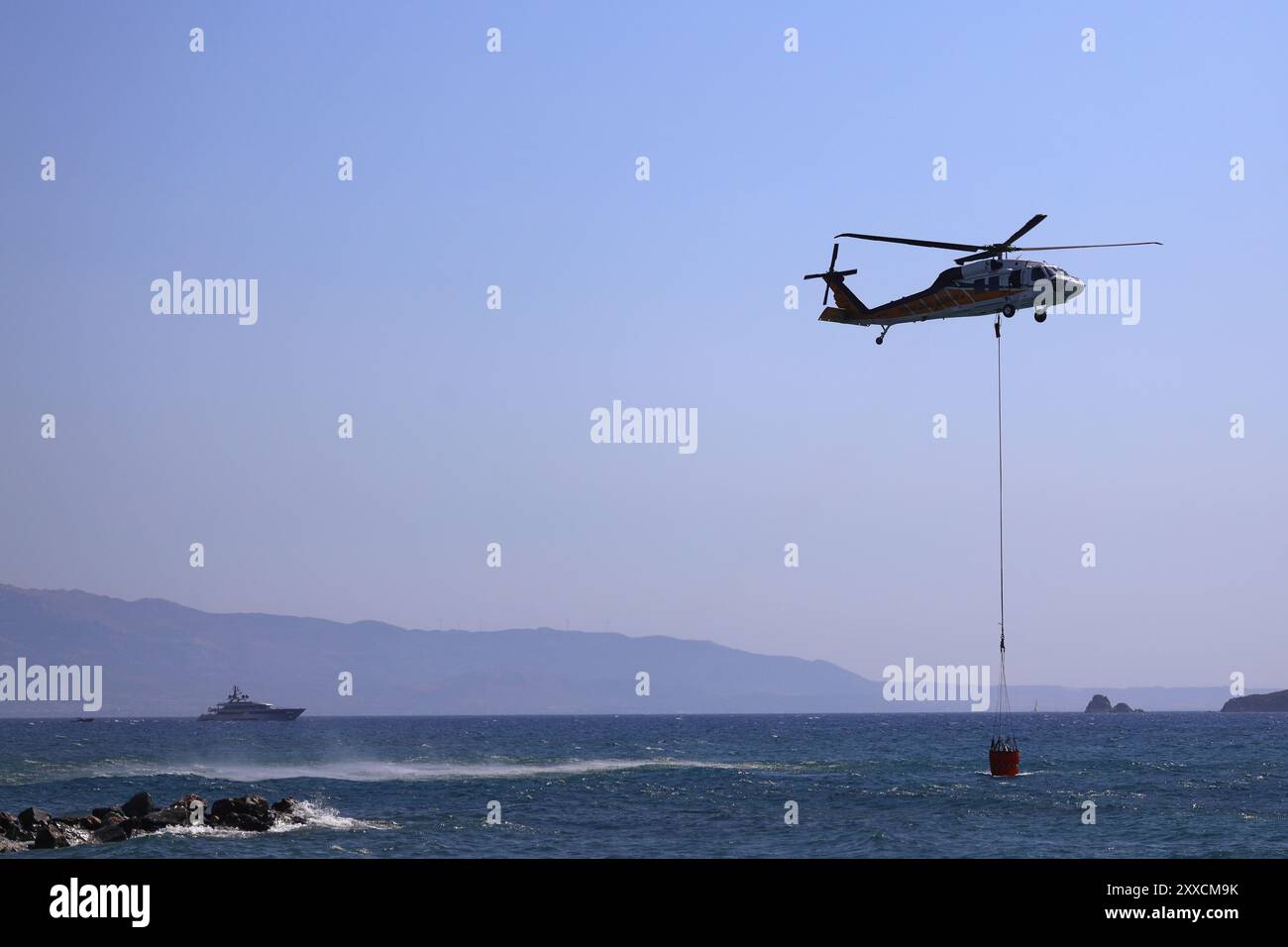 Bodrum, Turchia. 16 agosto 2024: Un elicottero antincendio prende l'acqua dal mare. Foto Stock