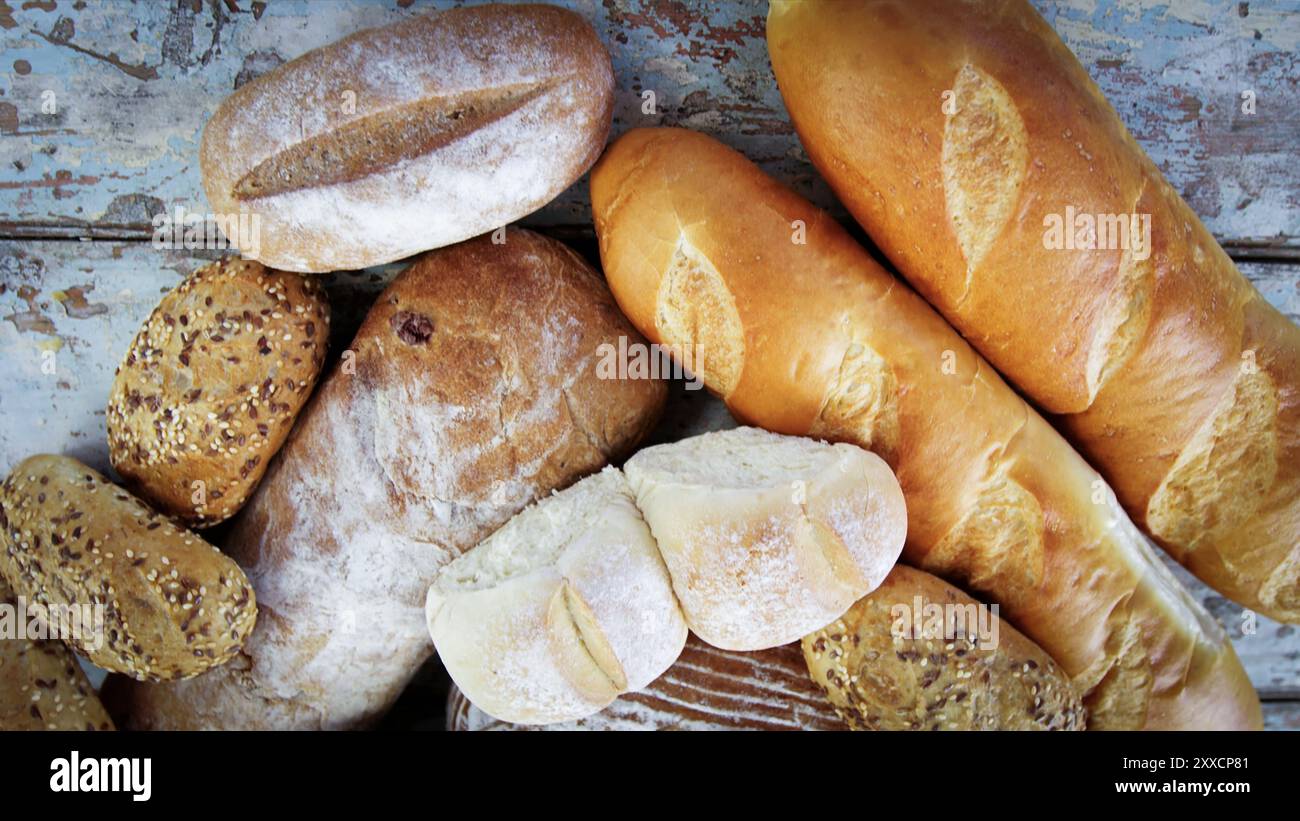 Varietà di pane a lievitazione naturale su una pagnotta di legno di pane artigianale. Pane fresco e fragrante sul tavolo. Concetto alimentare . Diversi tipi di pane. Foto Stock
