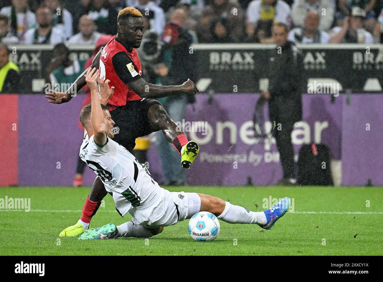 Moenchengladbach, Germania. 23 agosto 2024. Victor Boniface (indietro) del Bayer 04 Leverkusen spara durante la partita di prima divisione di Bundesliga tra Borussia Moenchengladbach e Bayer 04 Leverkusen a Moenchengladbach, Germania, 23 agosto 2024. Crediti: Ulrich Hufnagel/Xinhua/Alamy Live News Foto Stock