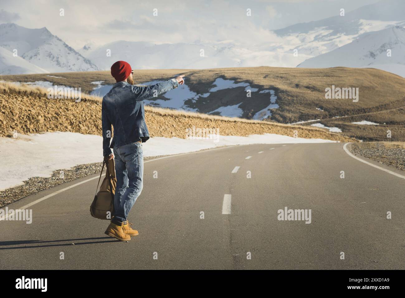 Concetto di turismo e persone, elegante hipster che cammina lungo le strade di campagna all'aperto e punta il dito verso qualcosa Foto Stock