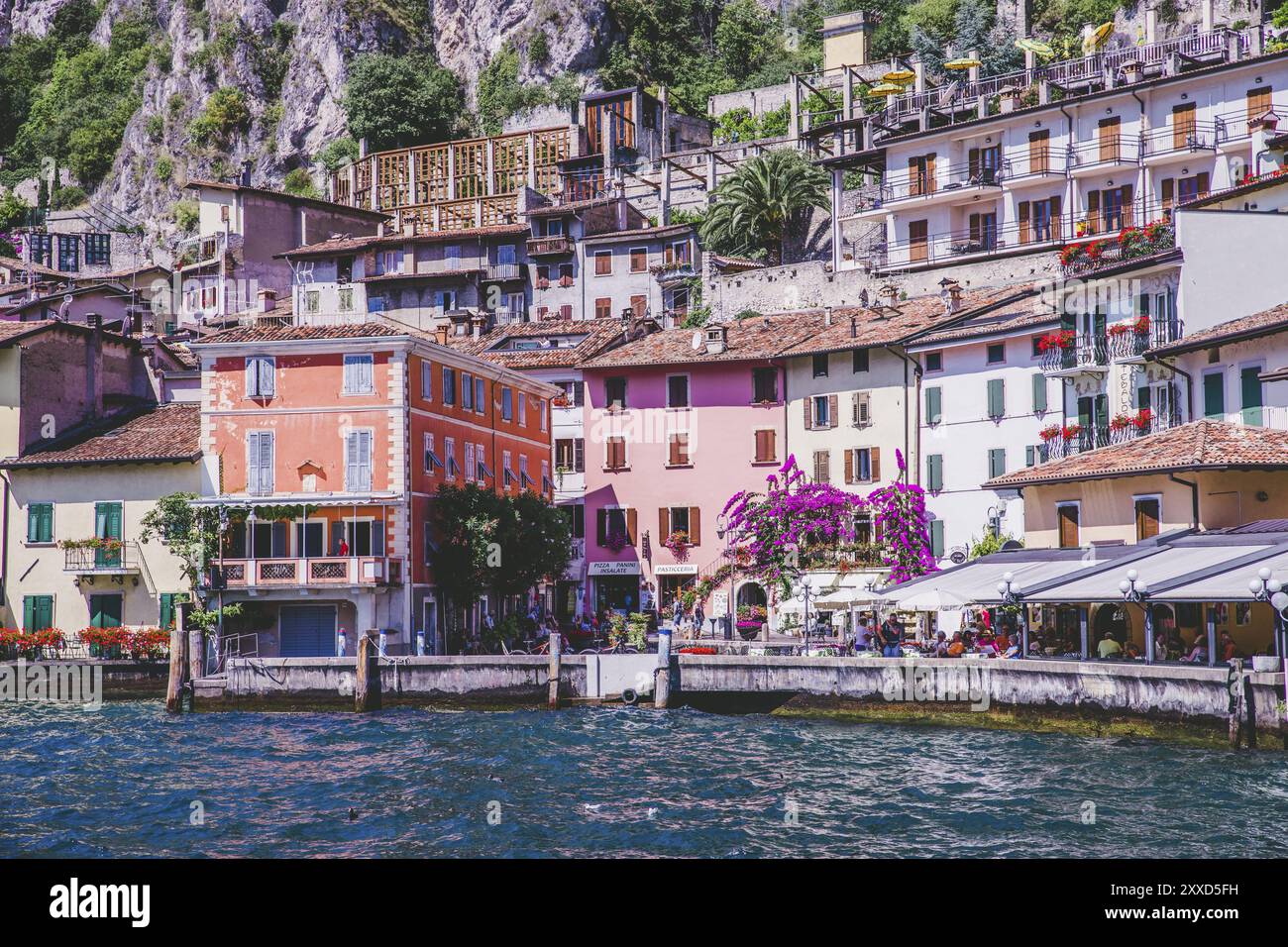 Costa idilliaco scenario in Italia, catturato dall'acqua. Acqua blu e un grazioso villaggio al lago di Garda, Limone Foto Stock