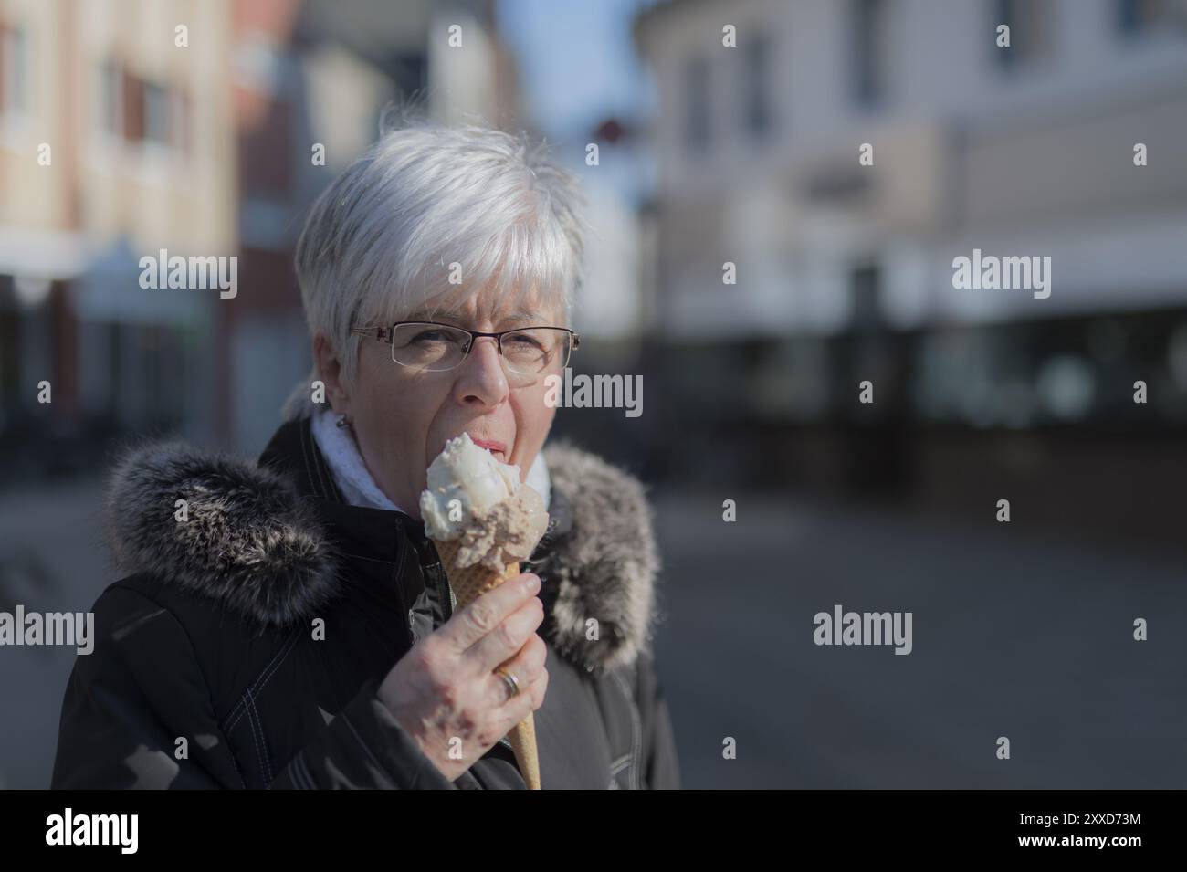 Una signora anziana con una porzione di gelato Foto Stock