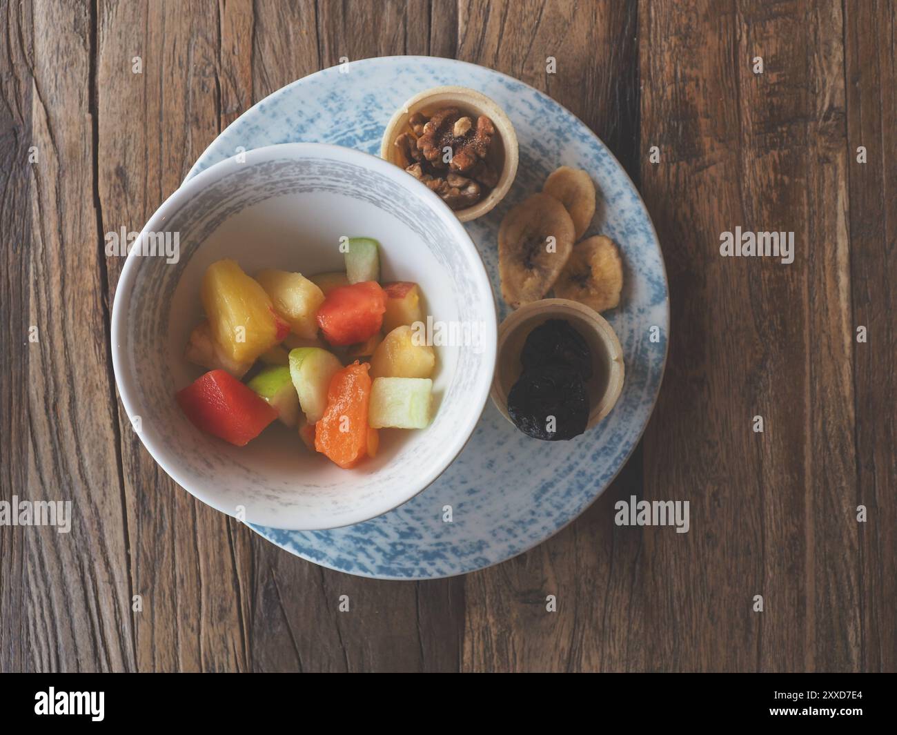 Una sana prima colazione, succosa con insalata di frutta secca su una tavola in legno rustico, cibo vegetariano o mangiare sano concetto Foto Stock