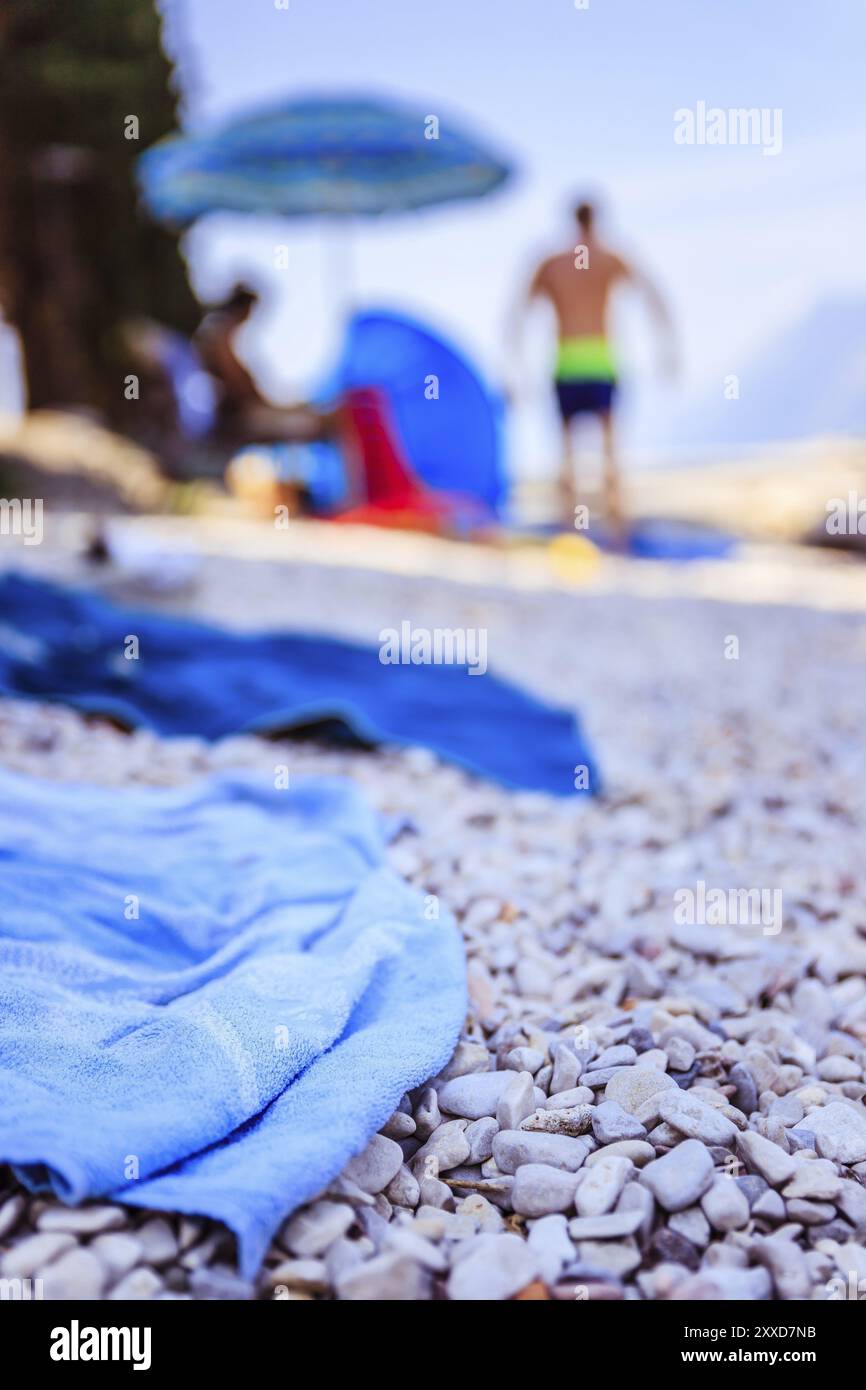 Asciugamano da bagno sulla spiaggia, altre persone con sfondo sfocato Foto Stock