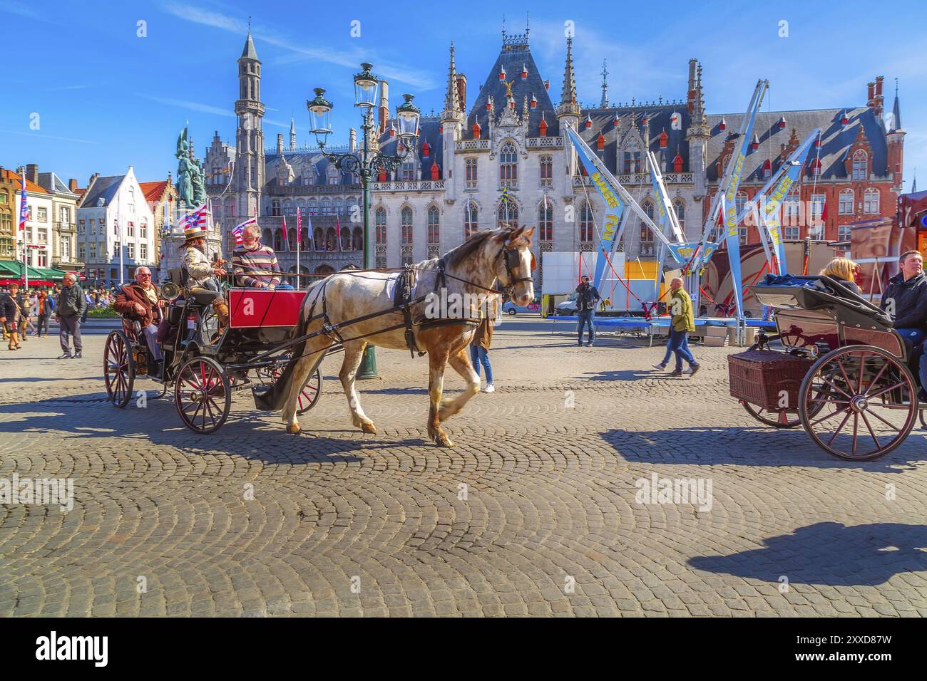 Bruges, Belgio, 10 aprile 2016: Carrozza trainata da cavalli sulla piazza del mercato nella popolare destinazione belga Bruges, Europa Foto Stock