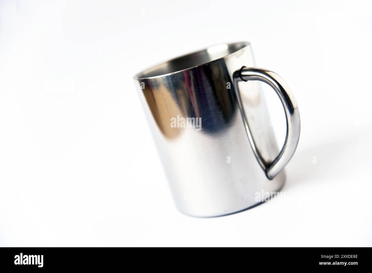 Tazza di metallo davanti a uno sfondo bianco Foto Stock