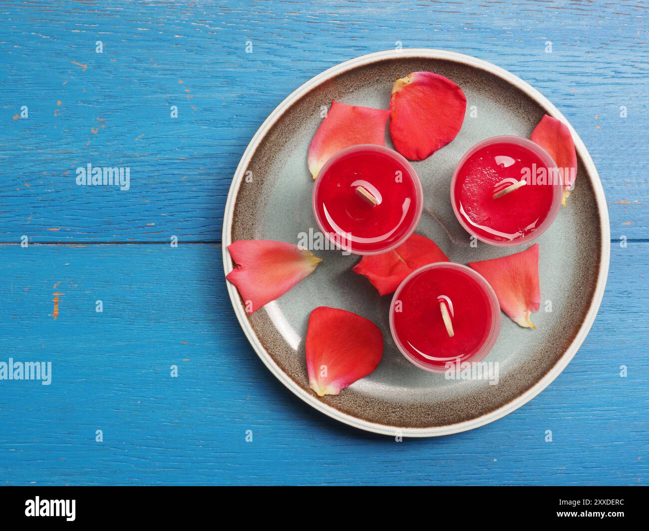 Fruttato rosso acqua ghiacciata su una piastra di colore blu Foto Stock