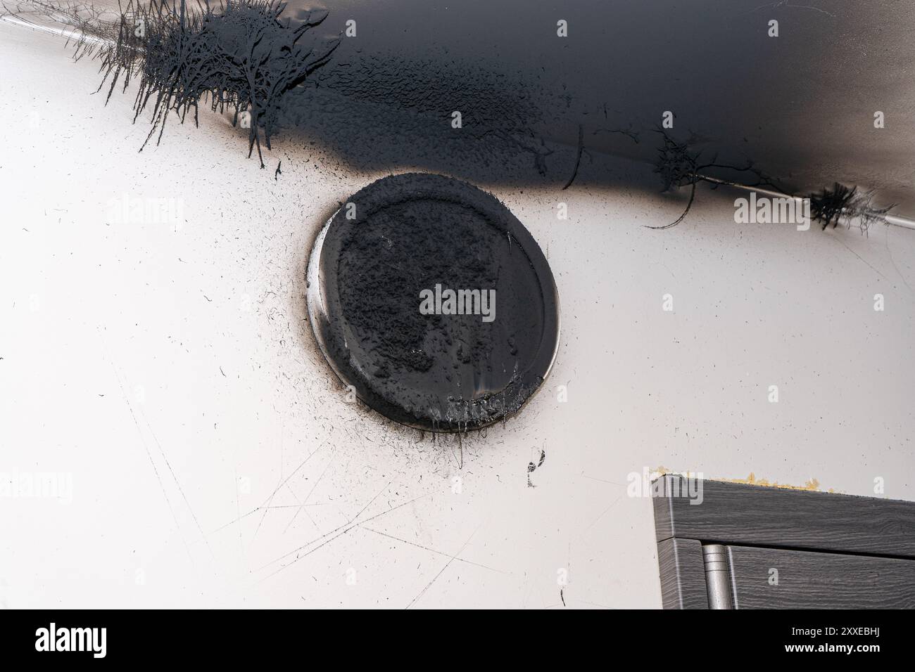 Lampada LED bruciata. Una lampada a paralume sulla parete dopo un incendio. Combustione spontanea e incendio in un edificio residenziale. Ustione interna Foto Stock