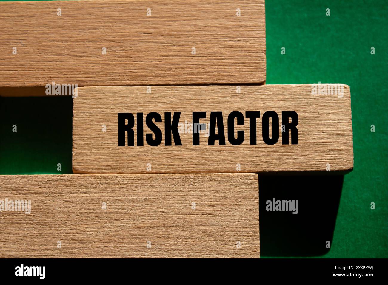 Messaggio sul fattore di rischio scritto su un blocco di legno con sfondo verde. Simbolo del fattore di rischio concettuale. Copia spazio. Foto Stock