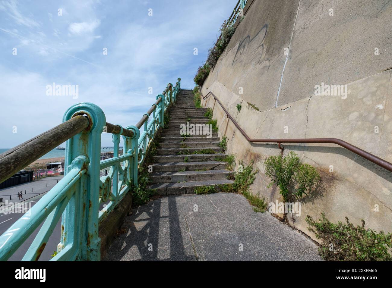 Scale che conducono al muro della scogliera Est il muro su Madeira Drive ha la prima targa verde del paese a segnare il muro Verde 150esimo anno. Foto Stock