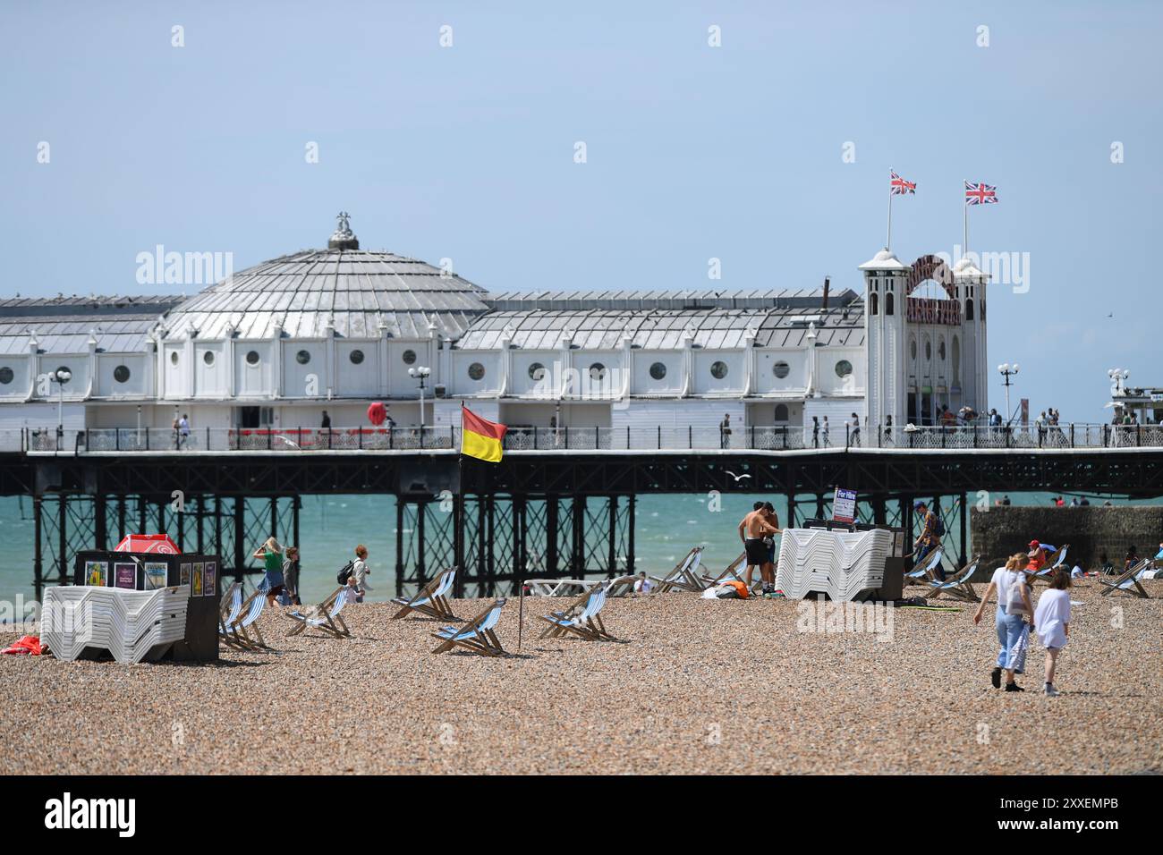 Vista sul lato sinistro del molo di Brighton scattata con un teleobiettivo con una spiaggia tranquilla con un numero limitato di persone in una giornata di sole. Foto Stock