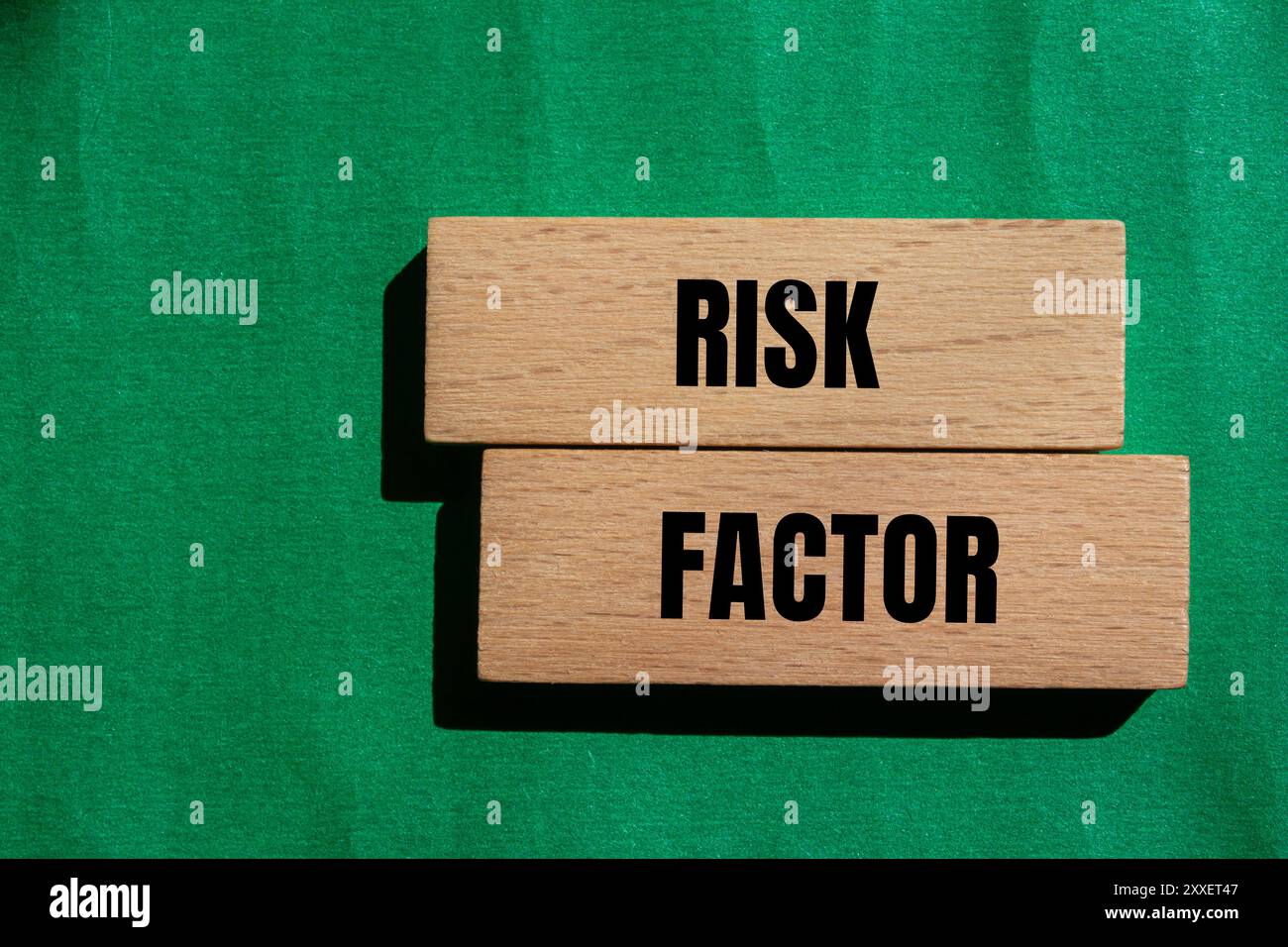 Messaggio sul fattore di rischio scritto su blocchi di legno con sfondo verde. Simbolo del fattore di rischio concettuale. Copia spazio. Foto Stock