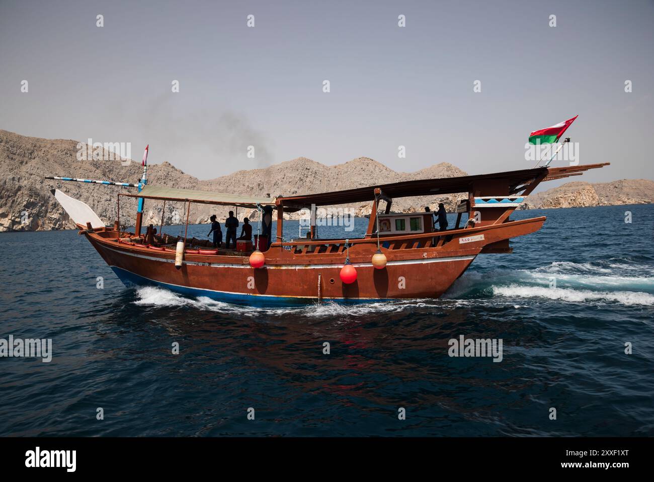 Tradizionali dhow arabi con turisti che navigano nelle acque simili a fiordi della penisola di Musandam, nel Sultanato dell'Oman Foto Stock