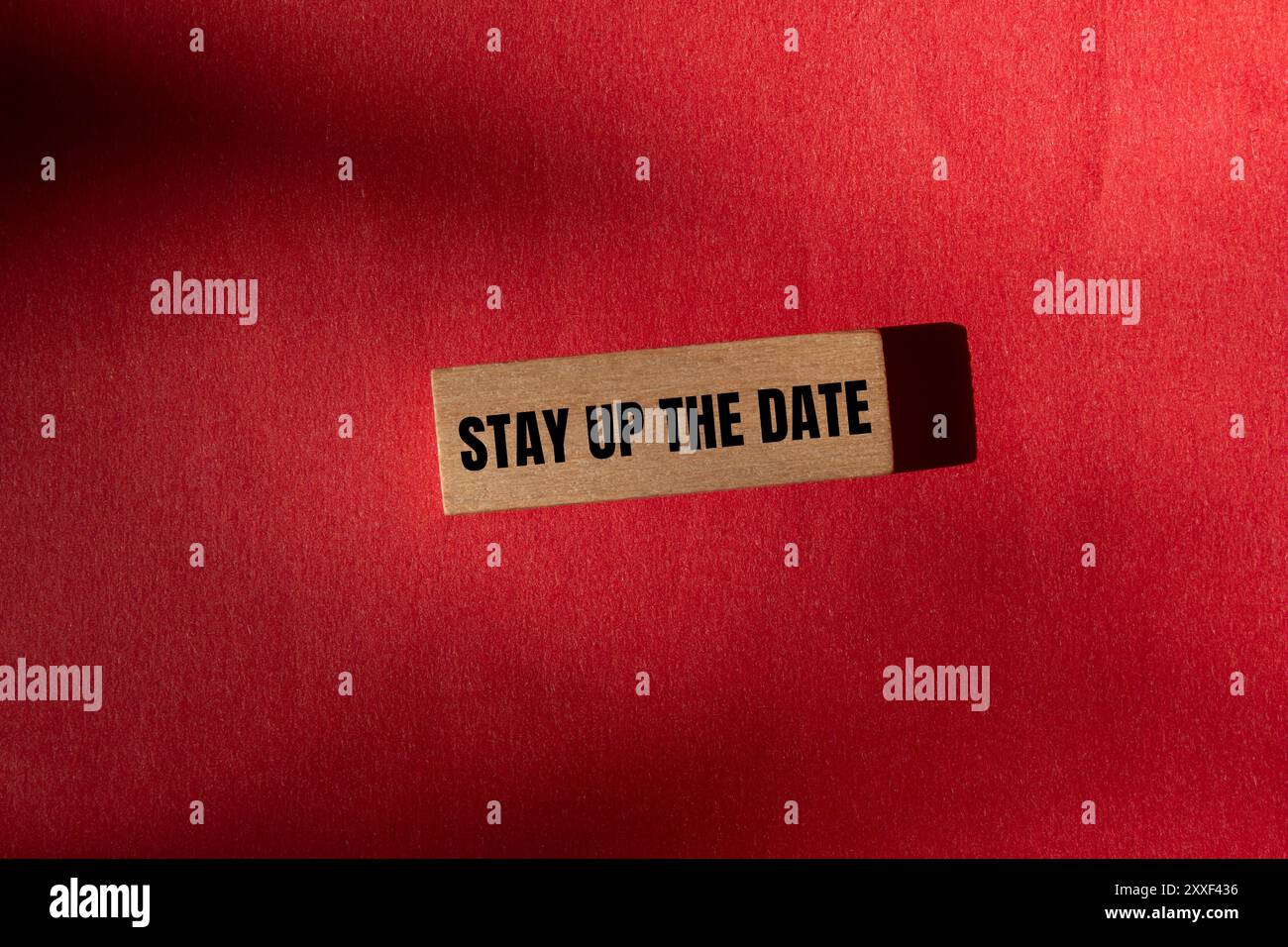 Rimani aggiornato sul messaggio di data scritto su un blocco di legno con sfondo rosso. Il simbolo della data resta aggiornato sul concetto. Copia spazio. Foto Stock