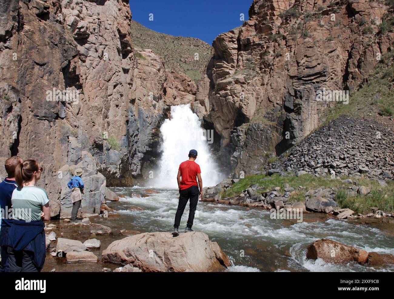 I turisti guardano una cascata nell'asia centrale del Kirghizistan Foto Stock