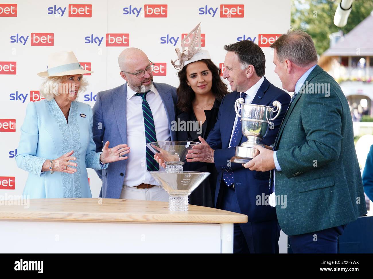 Regina Camilla con il vincitore del premio allenatore Henry de Bromhead e i collegamenti di Magical Zoe dopo aver vinto lo Sky Bet Ebor handicap durante il quarto giorno dello Sky Bet Ebor Festival all'ippodromo di York. Data foto: Sabato 24 agosto 2024. Foto Stock