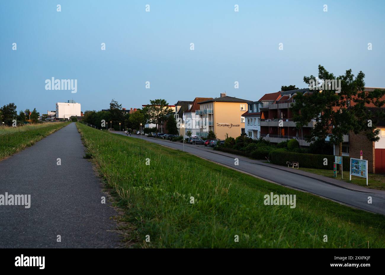 Dahme, Germania, 20 luglio 2024 - tramonto sulla diga con pista ciclabile sul mare. Foto Stock