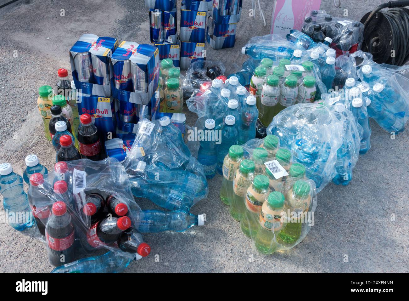 Una pila di bibite analcoliche in bottiglie di plastica e lattine di Red Bull da 0,3 l Foto Stock