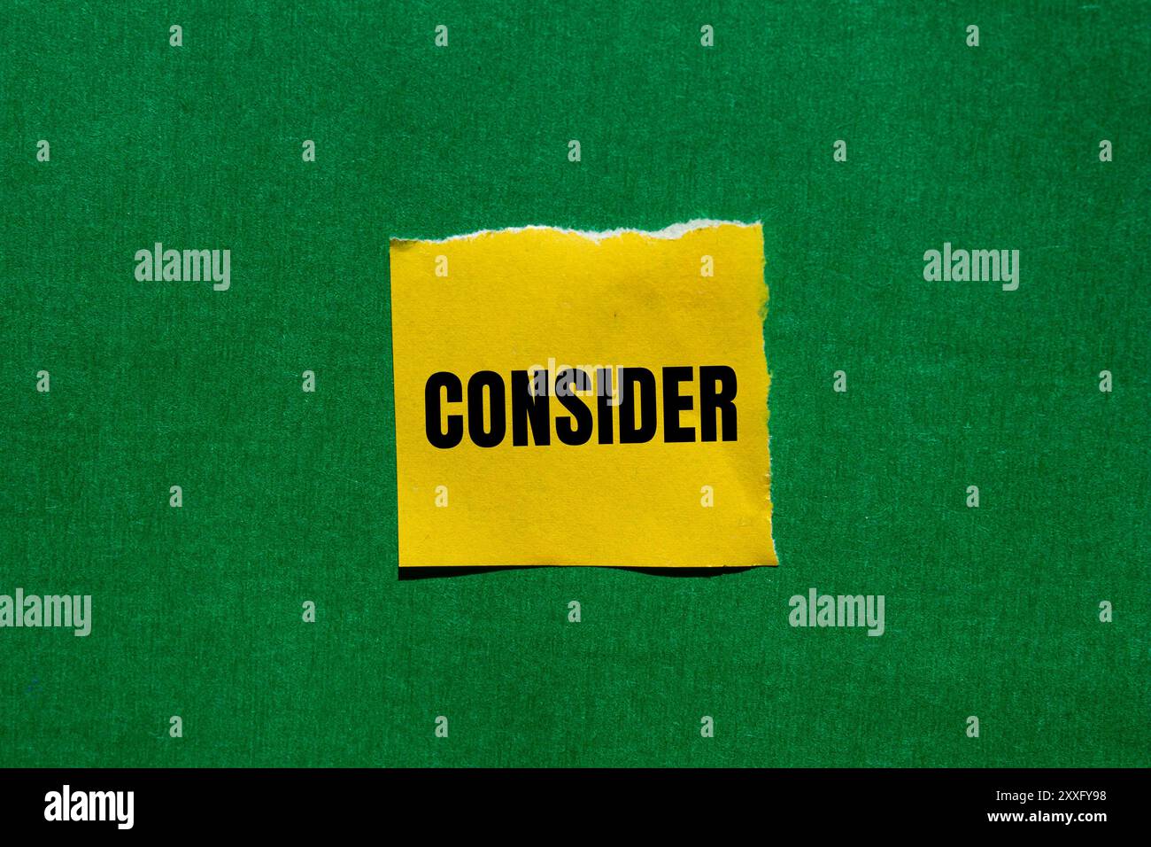 Considerare il messaggio scritto su un foglio di carta giallo strappato con sfondo verde. Simbolo concettuale da considerare. Copia spazio. Foto Stock