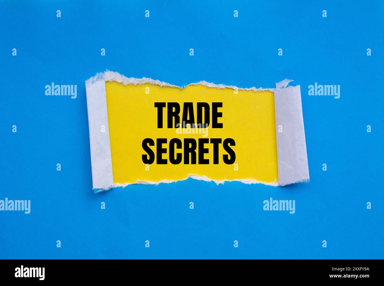 Messaggio segreto commerciale scritto su carta strappata blu con sfondo giallo. Simbolo dei segreti commerciali concettuali. Copia spazio. Foto Stock