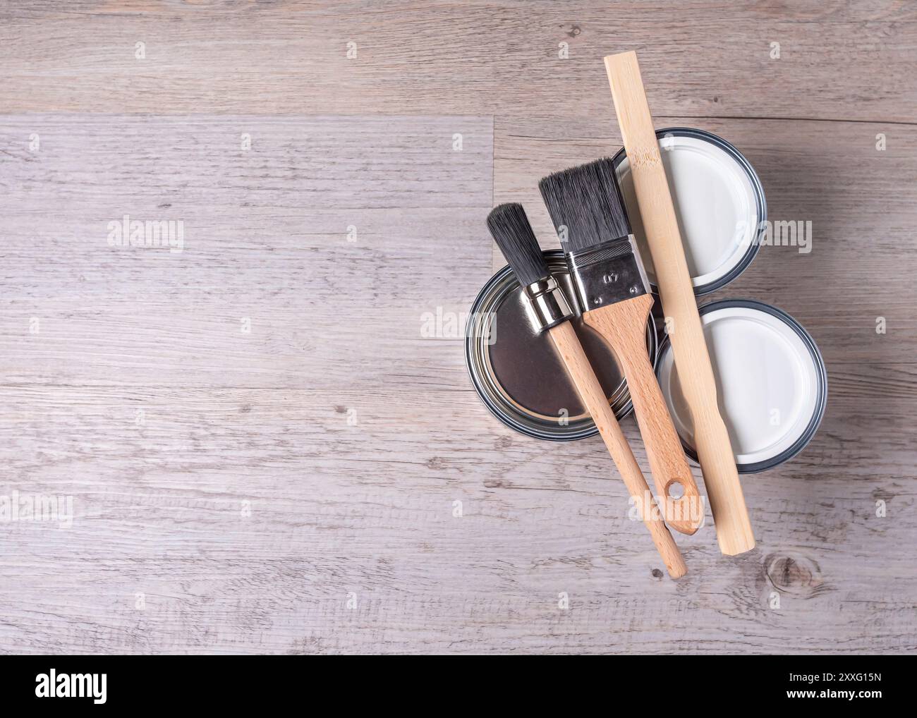 Ristrutturazione della casa, lattine di vernice e pennelli su sfondo in legno con spazio per fotocopie Foto Stock