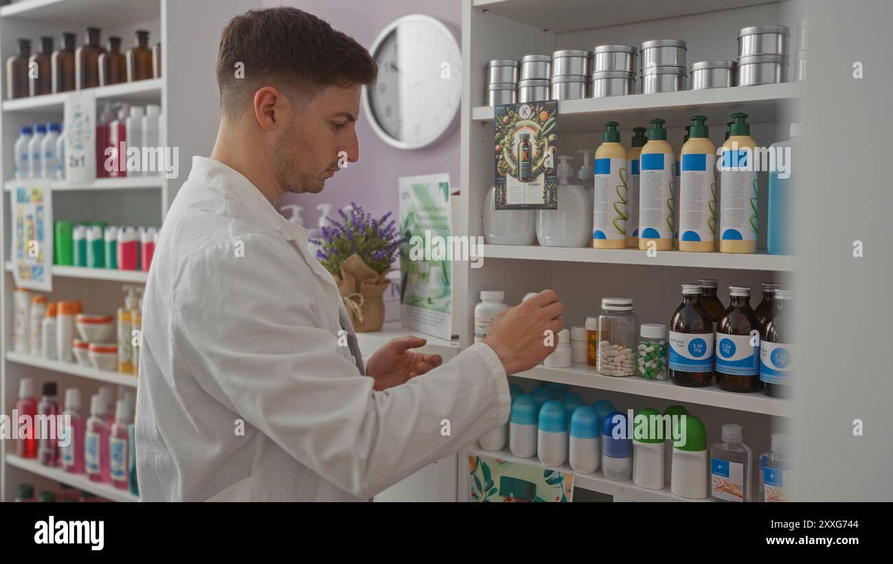 Un giovane ispanico in una farmacia si vede prendere un prodotto dallo scaffale, circondato da vari articoli di salute e bellezza in un setti di farmacia al coperto Foto Stock