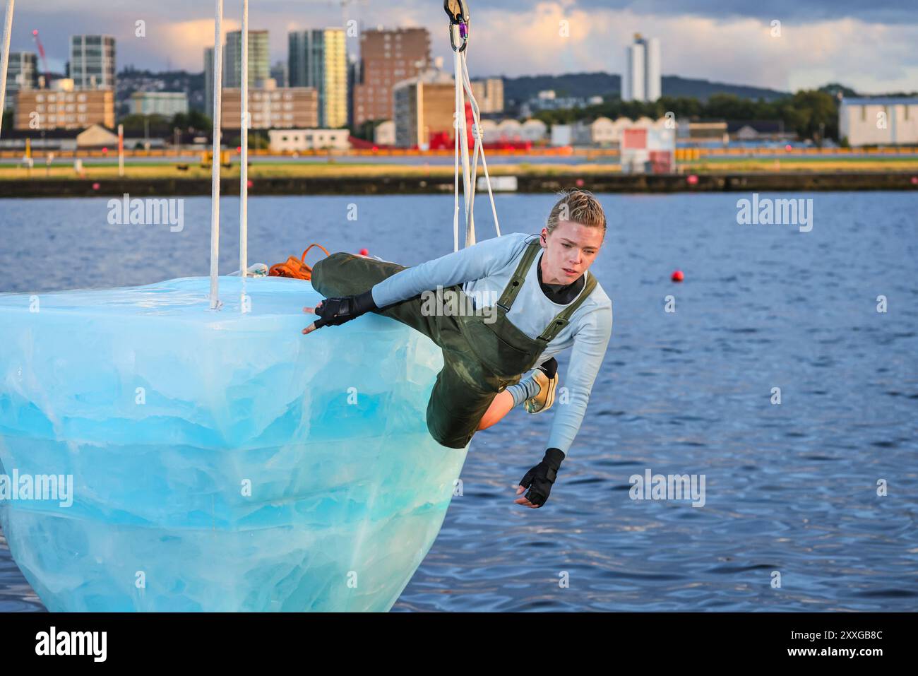 Londra, Regno Unito, 24 agosto 2024. Terza esecuzione, esecutore: Anna. THAW è la prima europea di uno spettacolo della compagnia teatrale australiana Legs on the Wall in risposta ai devastanti incendi boschivi del 2019/20 e ai cambiamenti climatici globali. Lo spettacolo, che si svolge presso il Docklands Campus della University of East London, porta gli spettatori faccia a faccia con l'urgente necessità di un'azione globale per il clima attraverso una performance di oltre 8 ore e vede un artista su un gigantesco blocco di ghiaccio fuso da 2,5 tonnellate sospeso da una gru alta. Crediti: Imageplotter/Alamy Live News Foto Stock