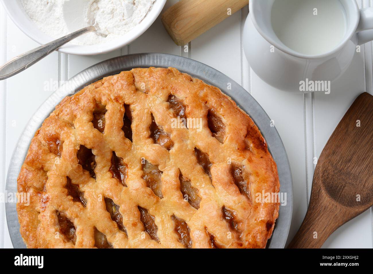 Torta di mele appena sfornata con crosta a reticolo. La torta è circondata da prodotti da forno. Angolo di Hogh. Formato orizzontale. Foto Stock