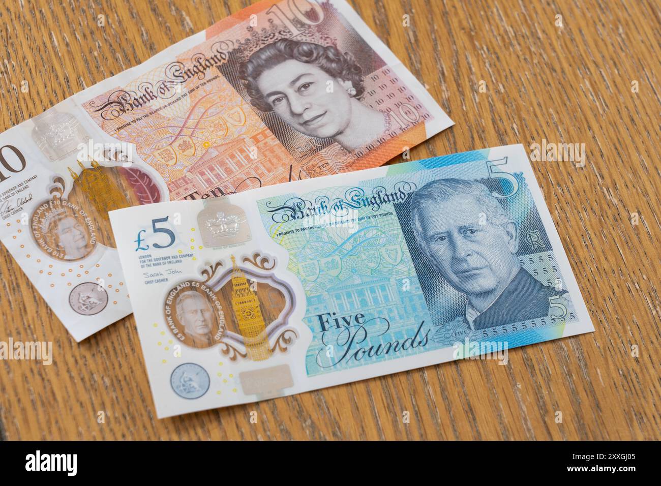 Banconote vecchie e nuove in polimero del Regno Unito - una banconota da dieci libbre con la testa della regina Elisabetta e una banconota da cinque libbre con la testa di re Carlo Foto Stock