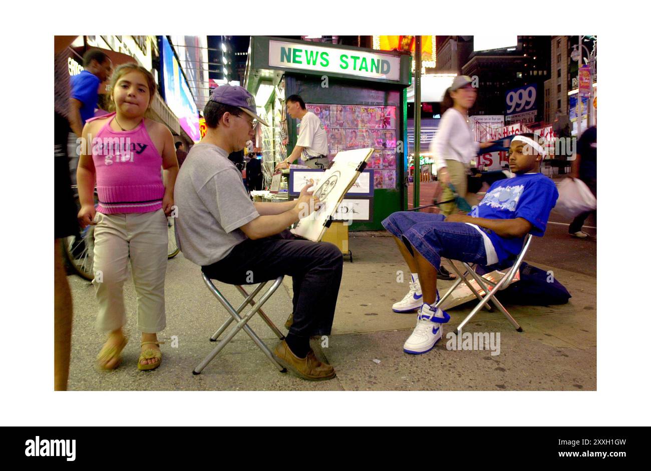 Gli artisti delle caricature attirano i turisti nei loro negozi sul marciapiede a Times Square. Foto Stock