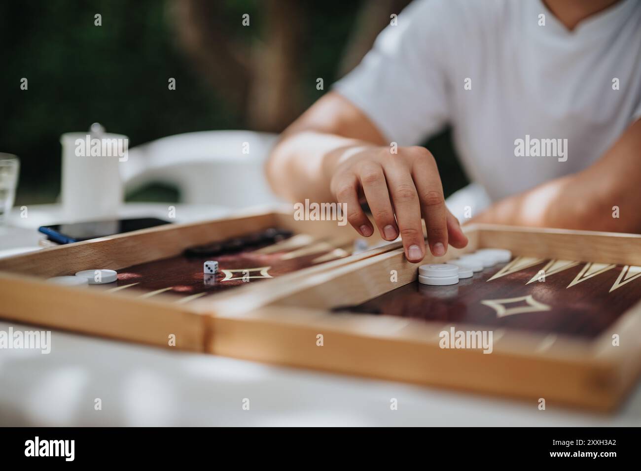 Persona che gioca a backgammon all'aperto in una giornata di sole da vicino Foto Stock