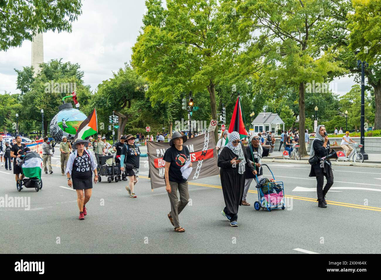 Washington DC, USA - 19/08/2024: Un gruppo di persone sta marciando lungo la strada tenendo cartelli e striscioni. I segni dicono "No War" e "No Peace" Foto Stock Washington DC, USA - 19/08/2024: Un gruppo di persone sta marciando lungo la strada tenendo cartelli e striscioni. I segni dicono "No War" e "No Peace" Foto Stock