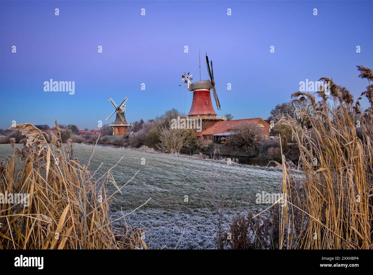 Mulini gemelli Greetsiel dopo una notte gelida, atmosfera da parodia, Krummhoern, Frisia orientale, bassa Sassonia, Germania, Europa Foto Stock