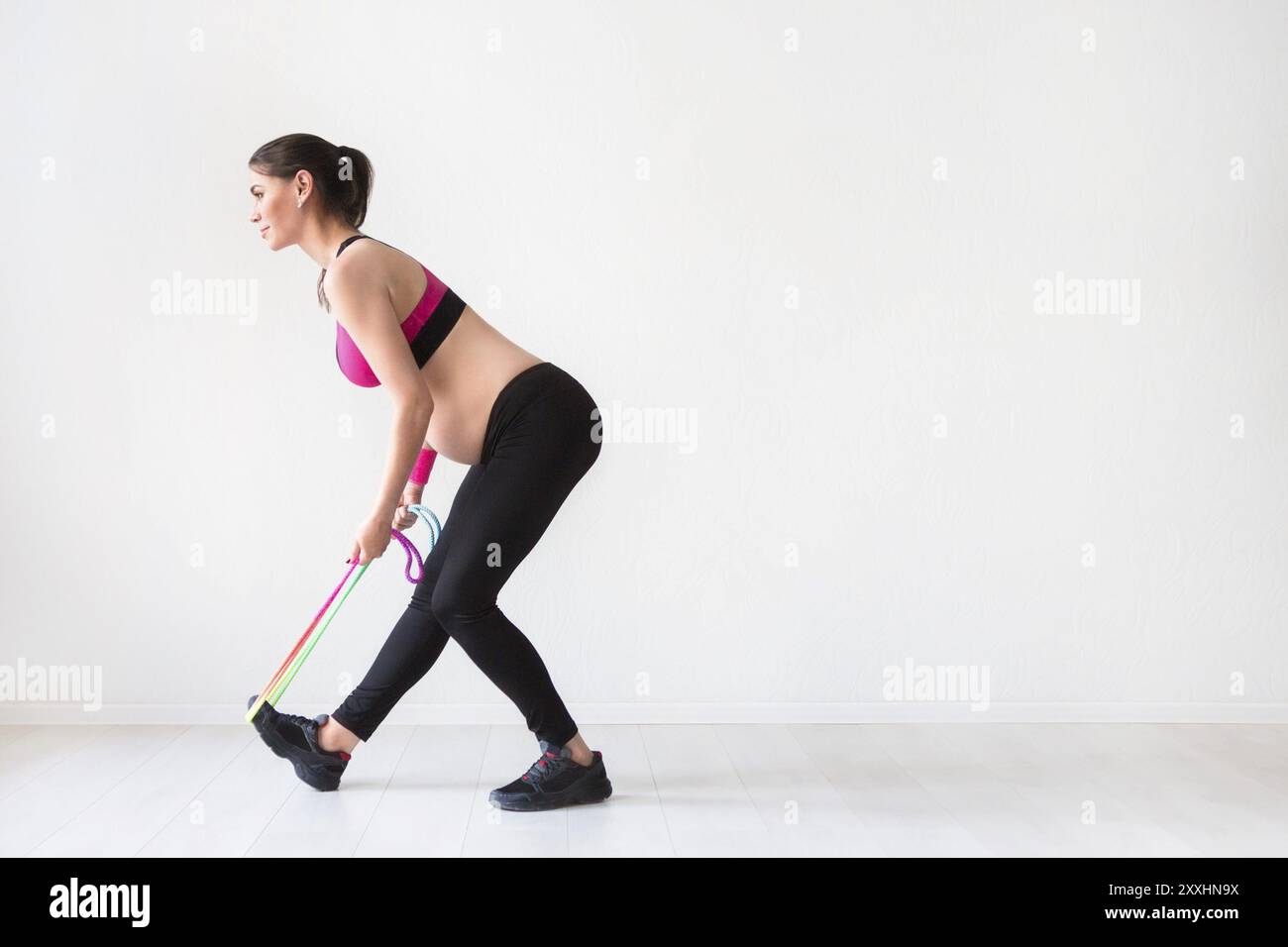 Una giovane donna incinta che fa esercizi di fitness in studio Foto Stock