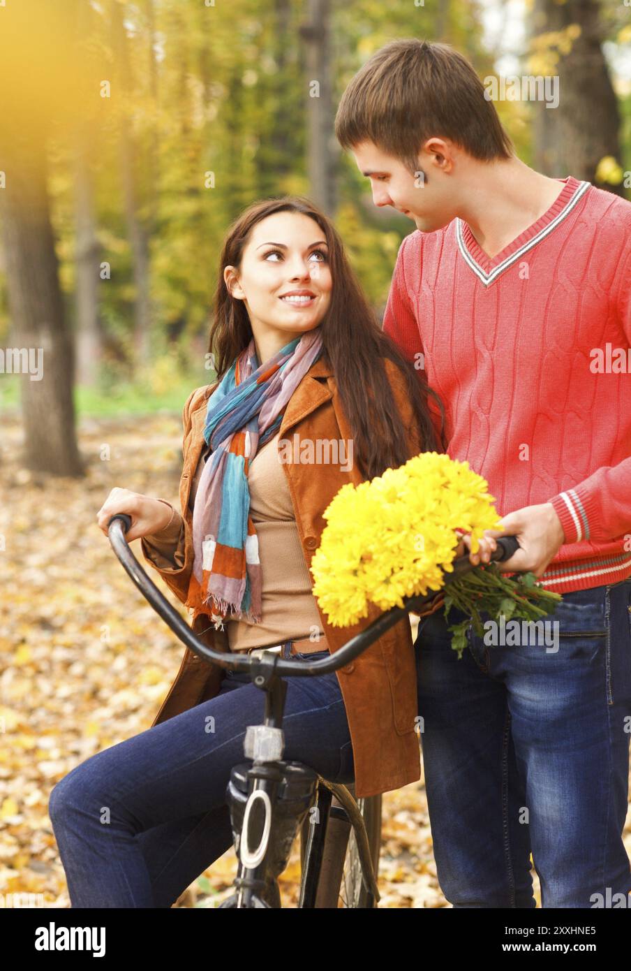 Felice coppia giovane con la bicicletta in autunno park Foto Stock