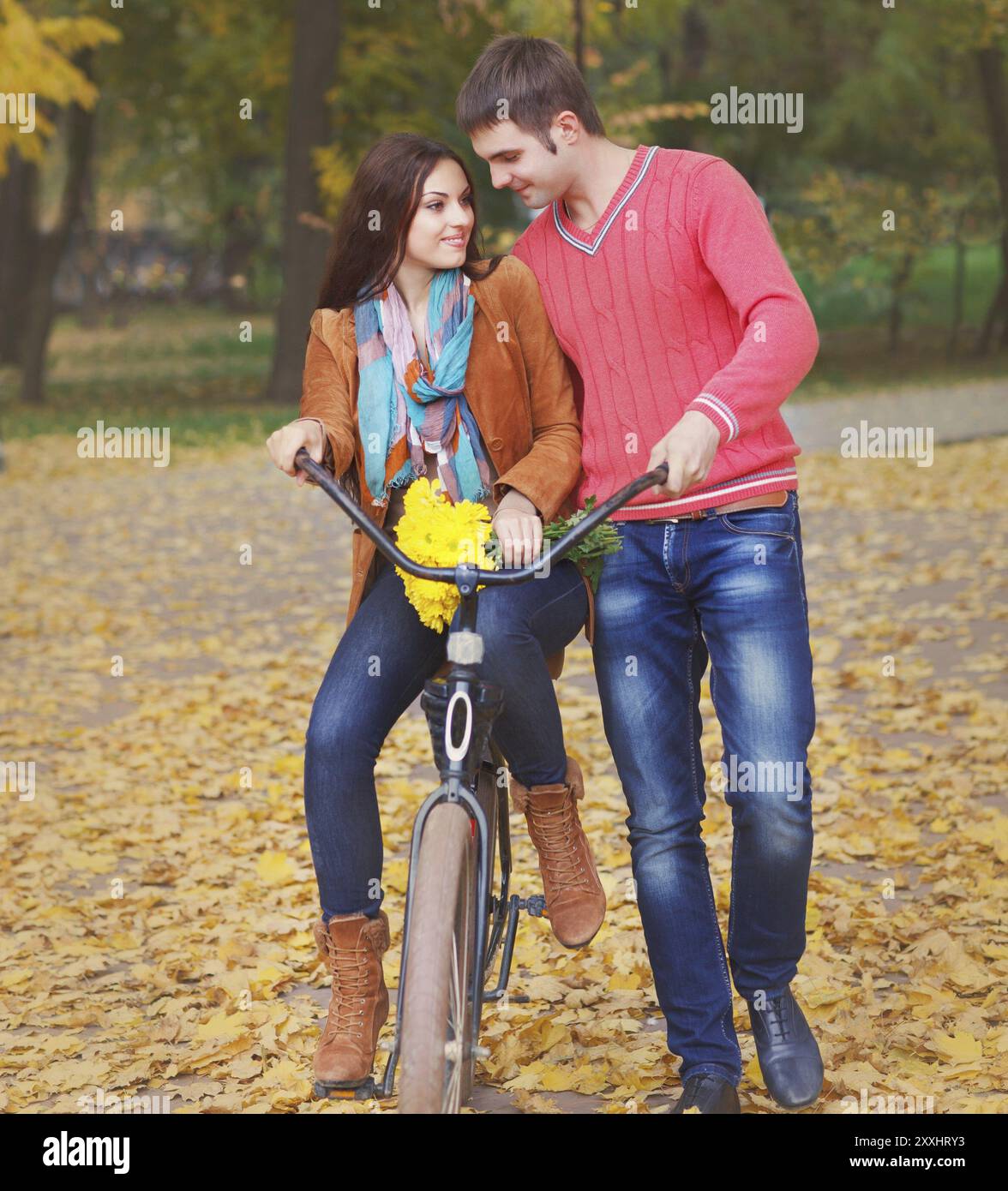 Felice coppia giovane con la bicicletta in autunno park Foto Stock