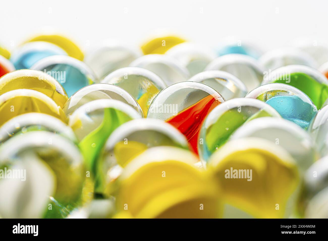 Marmi di vetro gialli, verdi, blu e rossi su un tavolo Foto Stock