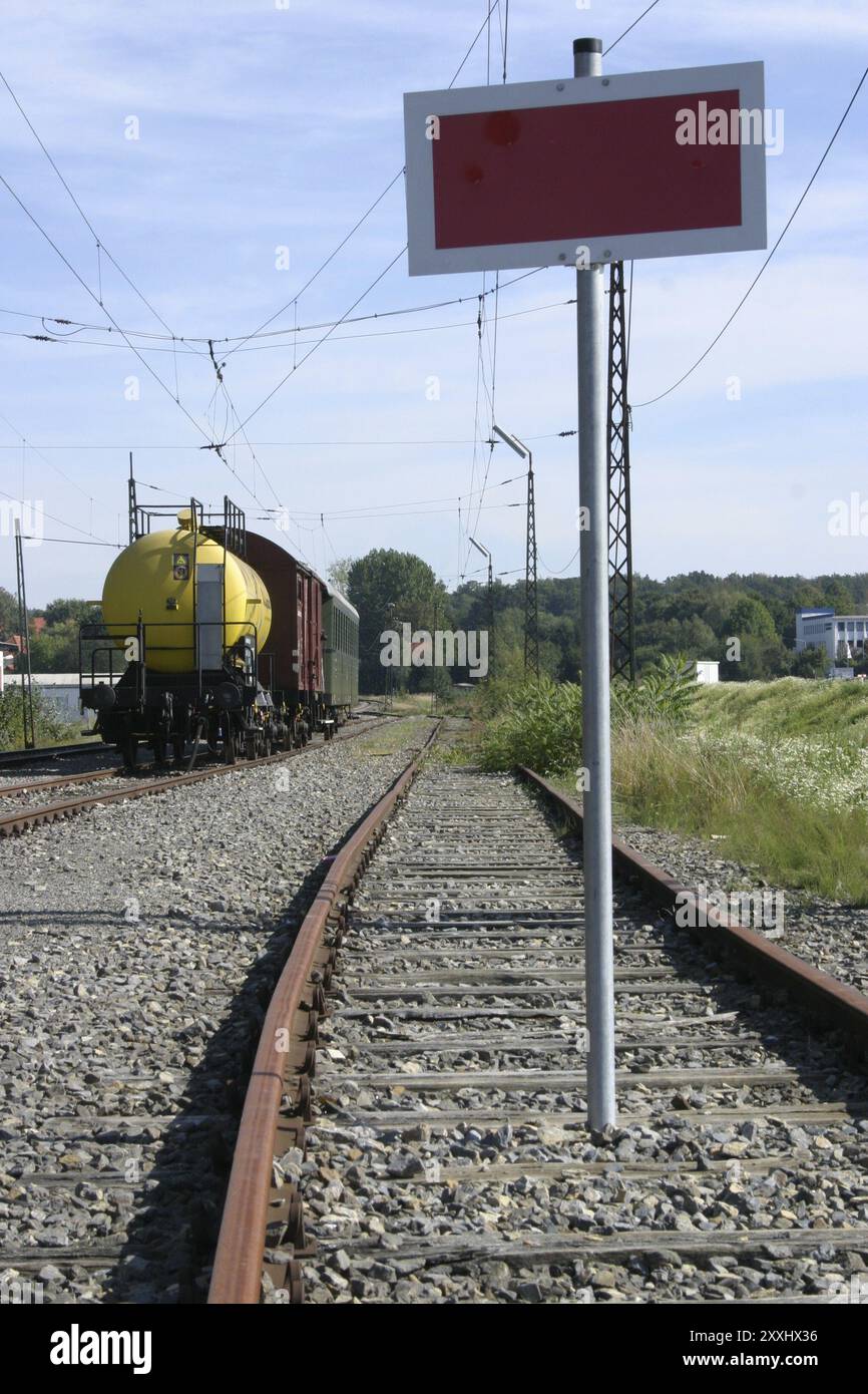 Linea ferroviaria con vagoni e cartello di chiusura stradale Foto Stock