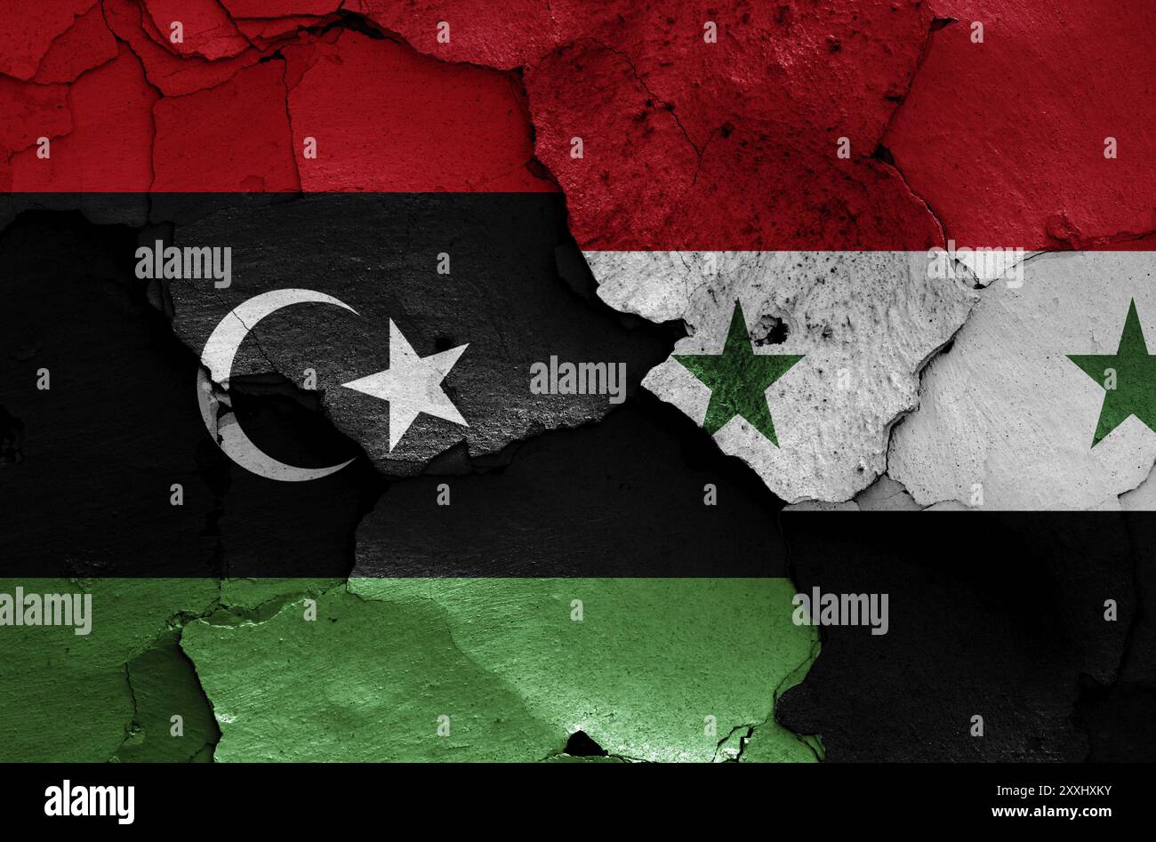 Bandiere di Libia e Siria dipinte su un muro incrinato Foto Stock