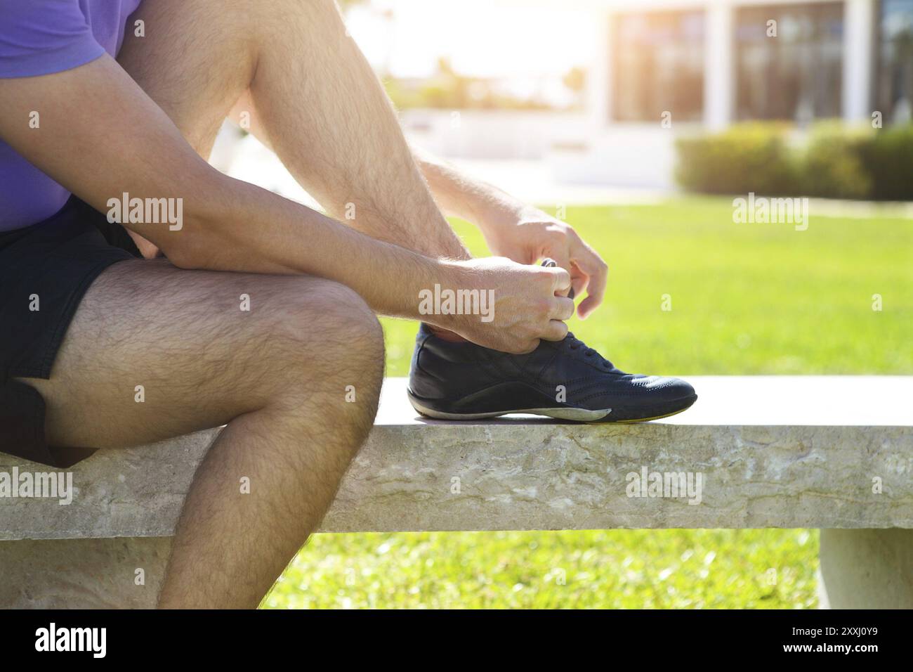 Atleta uomo cercando le scarpe running ottenere pronto per fare jogging nel parco Foto Stock