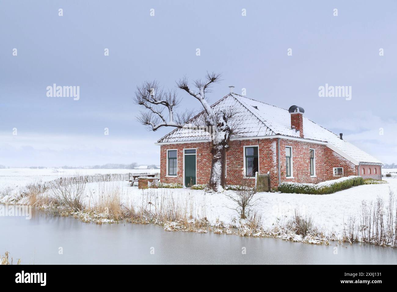 Affascinante casa sulla neve invernale sul fiume, Paesi Bassi Foto Stock