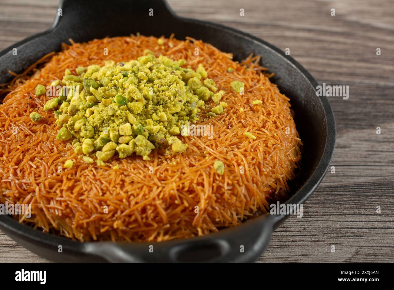Una vista di un knafeh in una pentola di ghisa. Foto Stock