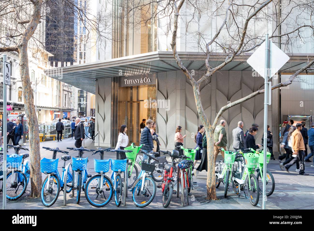 La gioielleria Tiffany & Co vince Sydney King Street, con biciclette elettriche da noleggiare all'aperto sul marciapiede mentre gli acquirenti passano a Sydney City Foto Stock