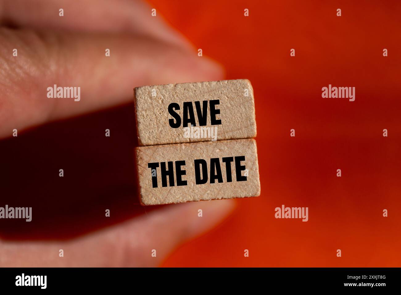 Salvare il messaggio con la data scritto su blocchi di legno con sfondo arancione. Salvare il simbolo della data concettuale. Copia spazio. Foto Stock
