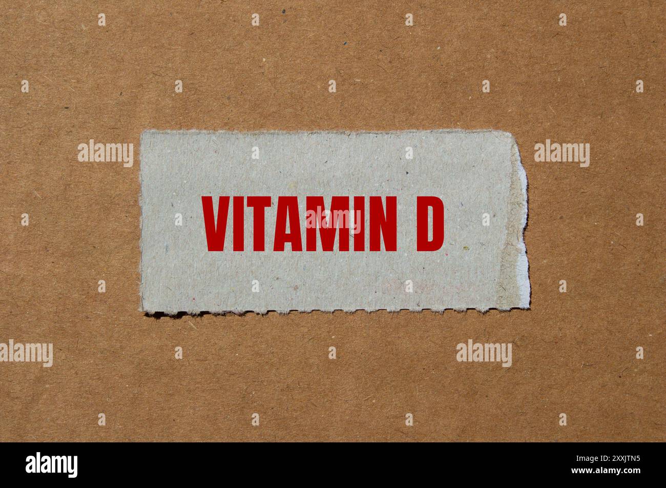 Messaggio di vitamina d scritto su un pezzo di carta strappato con sfondo di cartone. Simbolo concettuale della vitamina D. Copia spazio. Foto Stock