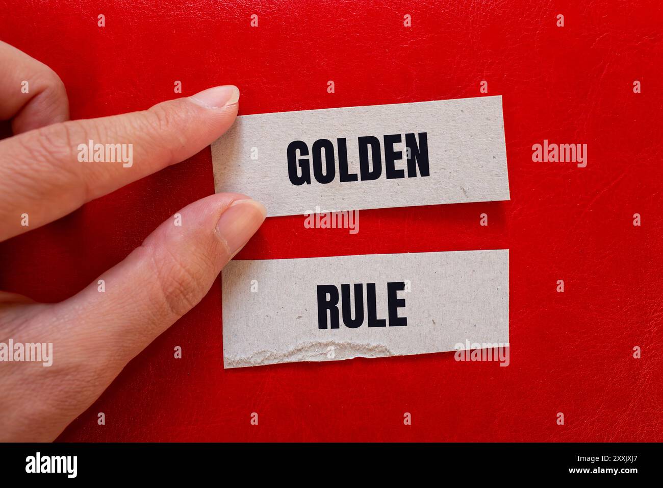 Messaggio della regola d'oro scritto su pezzi di carta con sfondo rosso. Simbolo della regola d'oro concettuale. Copia spazio. Foto Stock