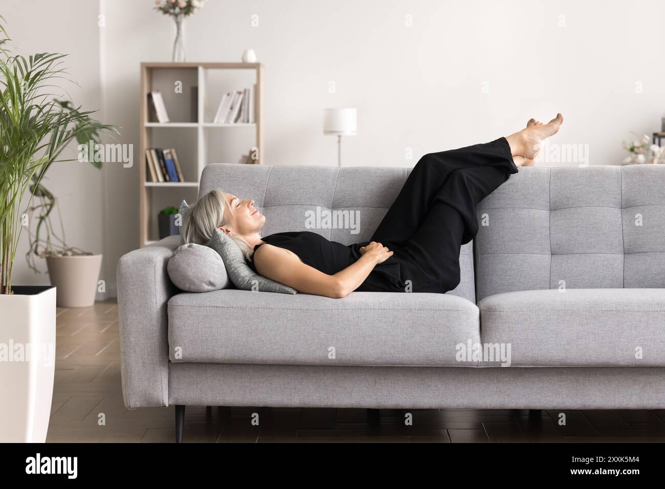 Donna che prende il momento per rilassarsi e rilassarsi dopo una lunga giornata Foto Stock