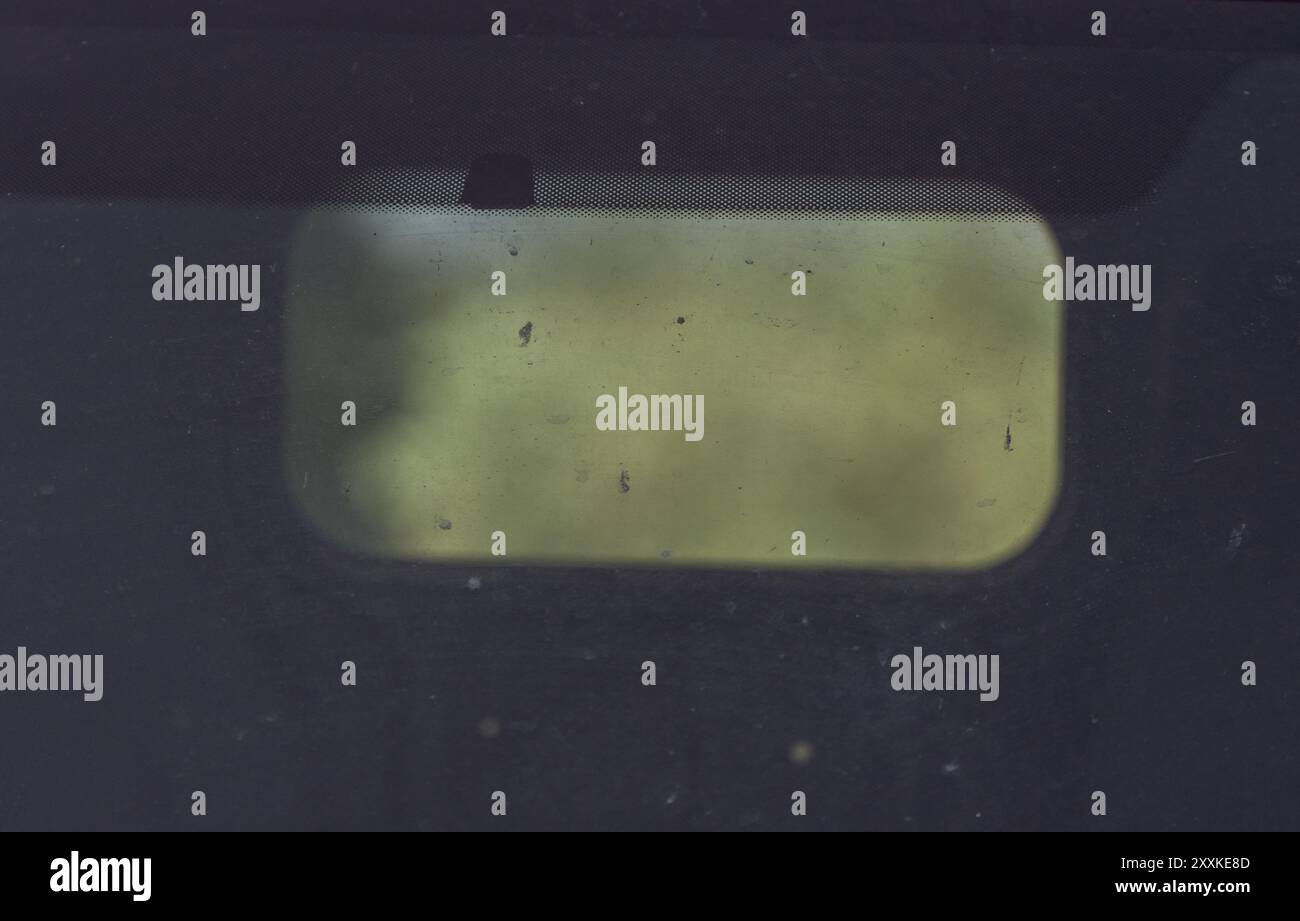Cornice ovale cinematografica. Verde sfocato attraverso un parabrezza sporco. Foto Stock